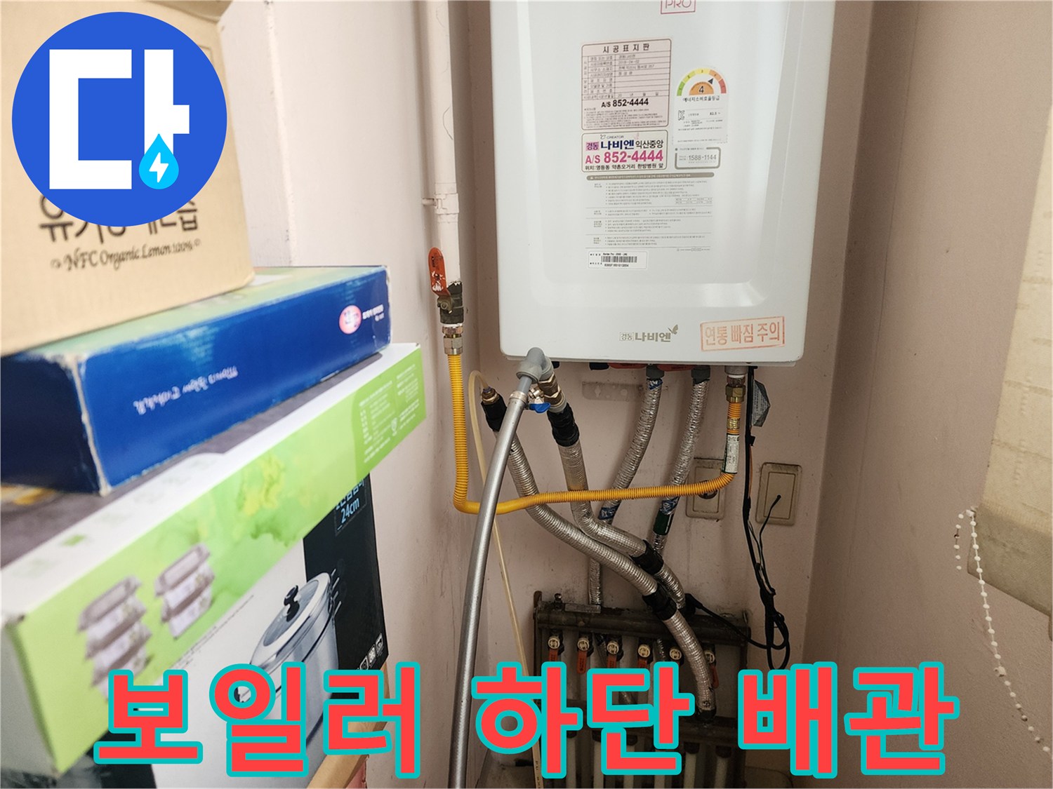 보일러 본체 아래로 연결된 은색 보온재 배관과 급수 밸브