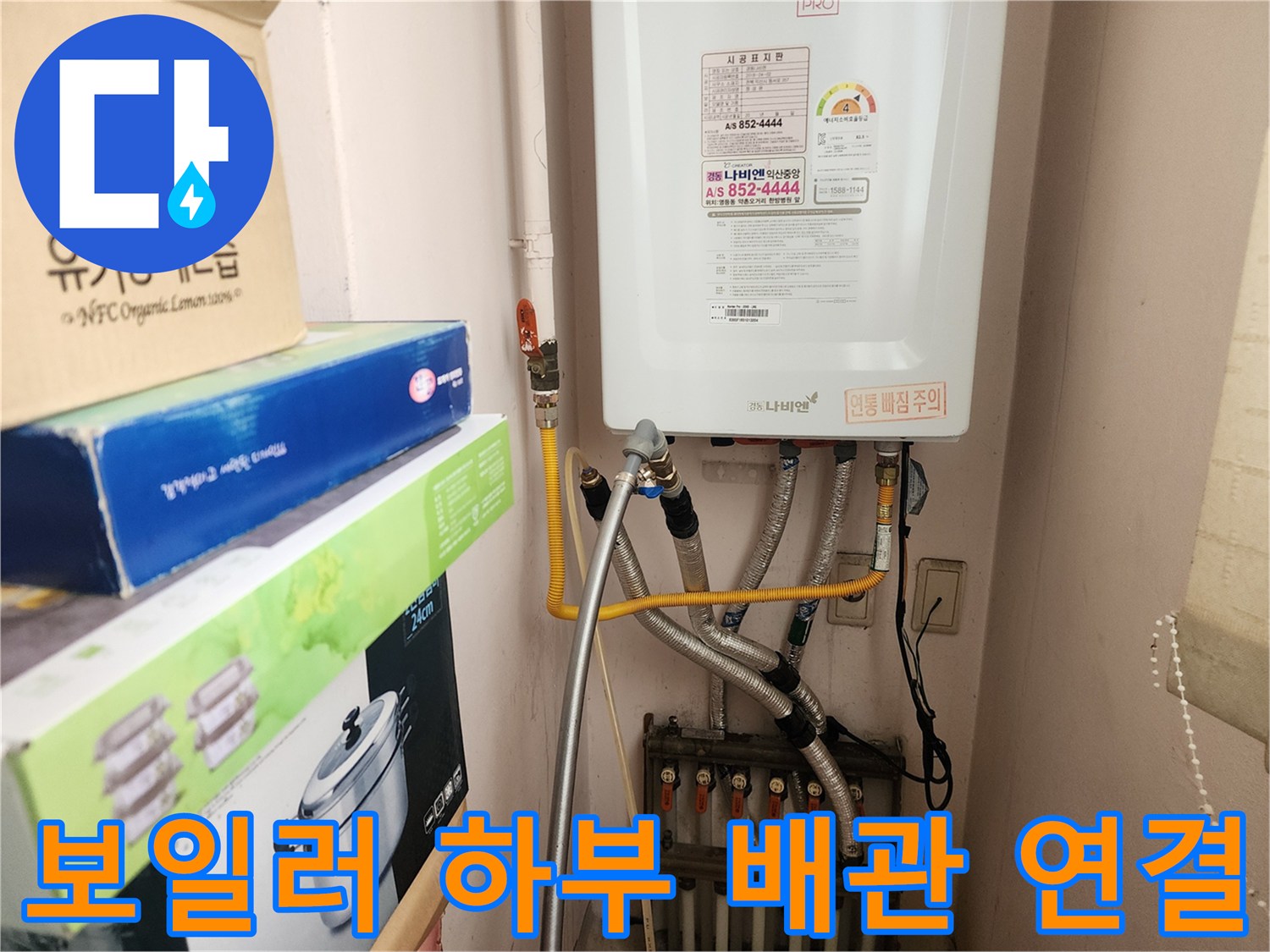 보일러 아래쪽의 급수 밸브와 은색 주름관 연결 부위