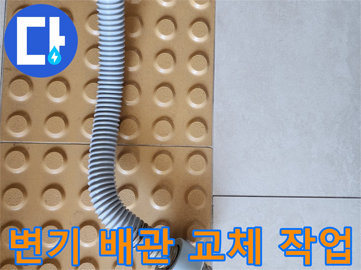 욕실 바닥 타일 위에 설치된 새로운 변기 배관 연결 부속