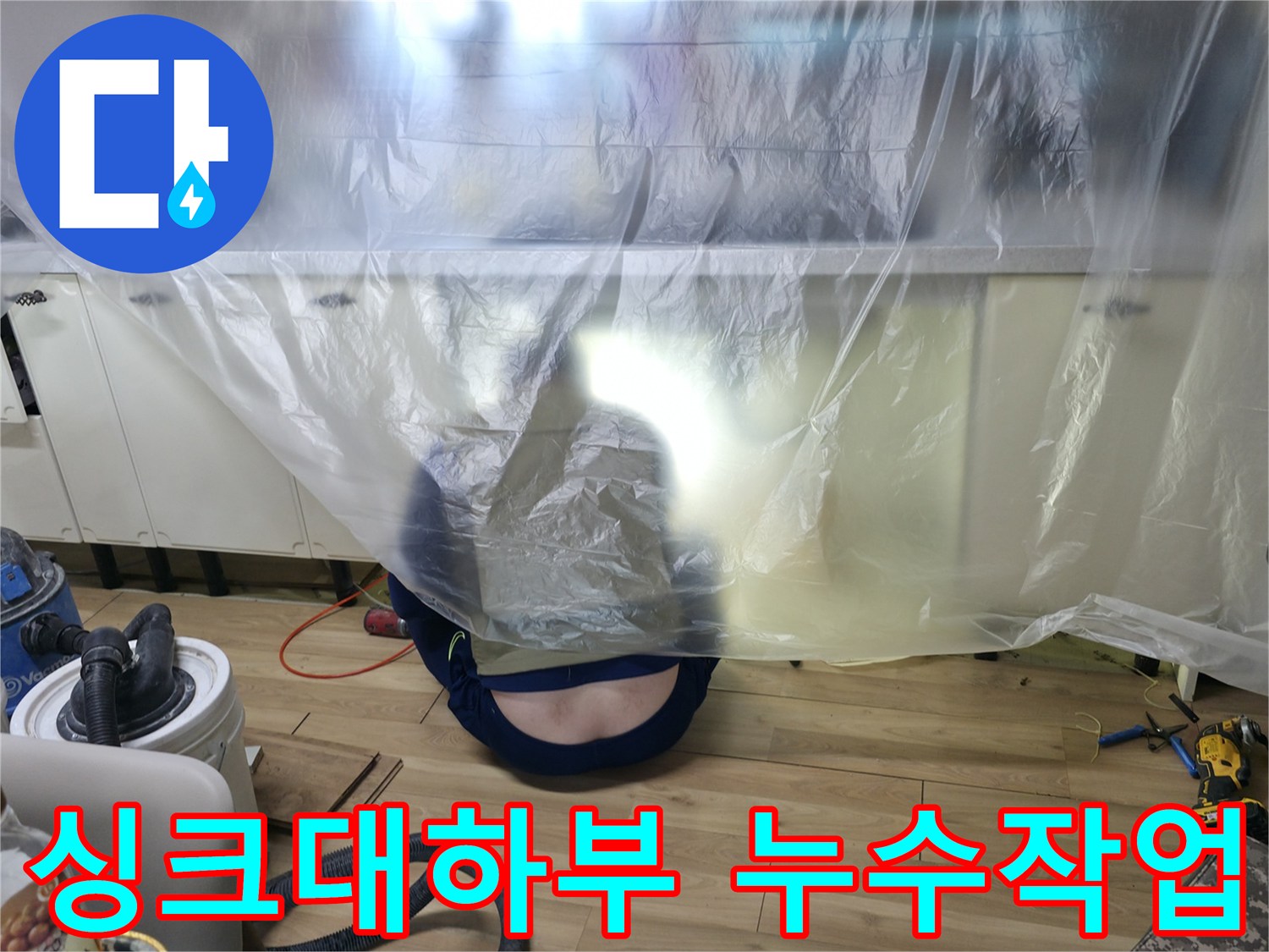 주방 싱크대 하부장 아래 배관 점검을 위해 비닐로 보양된 현장 모습