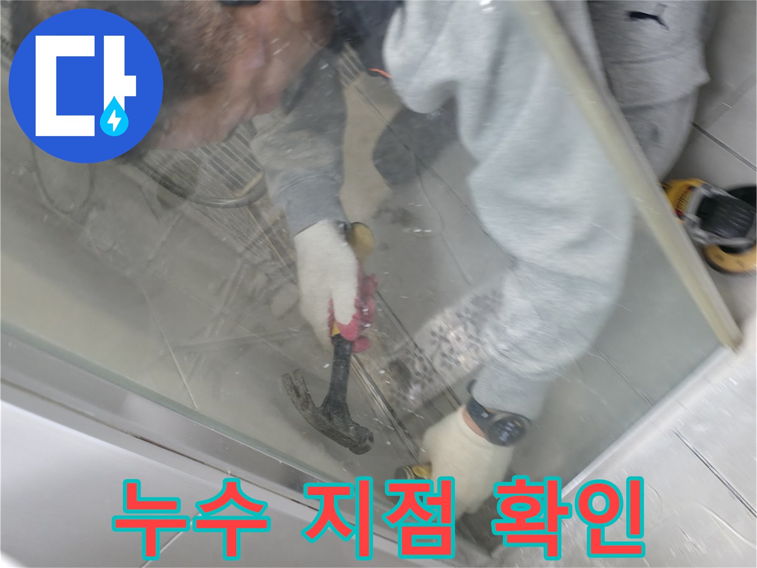 작업 현장에서 벽면 타일의 균열 상태를 정밀하게 점검하는 모습입니다.