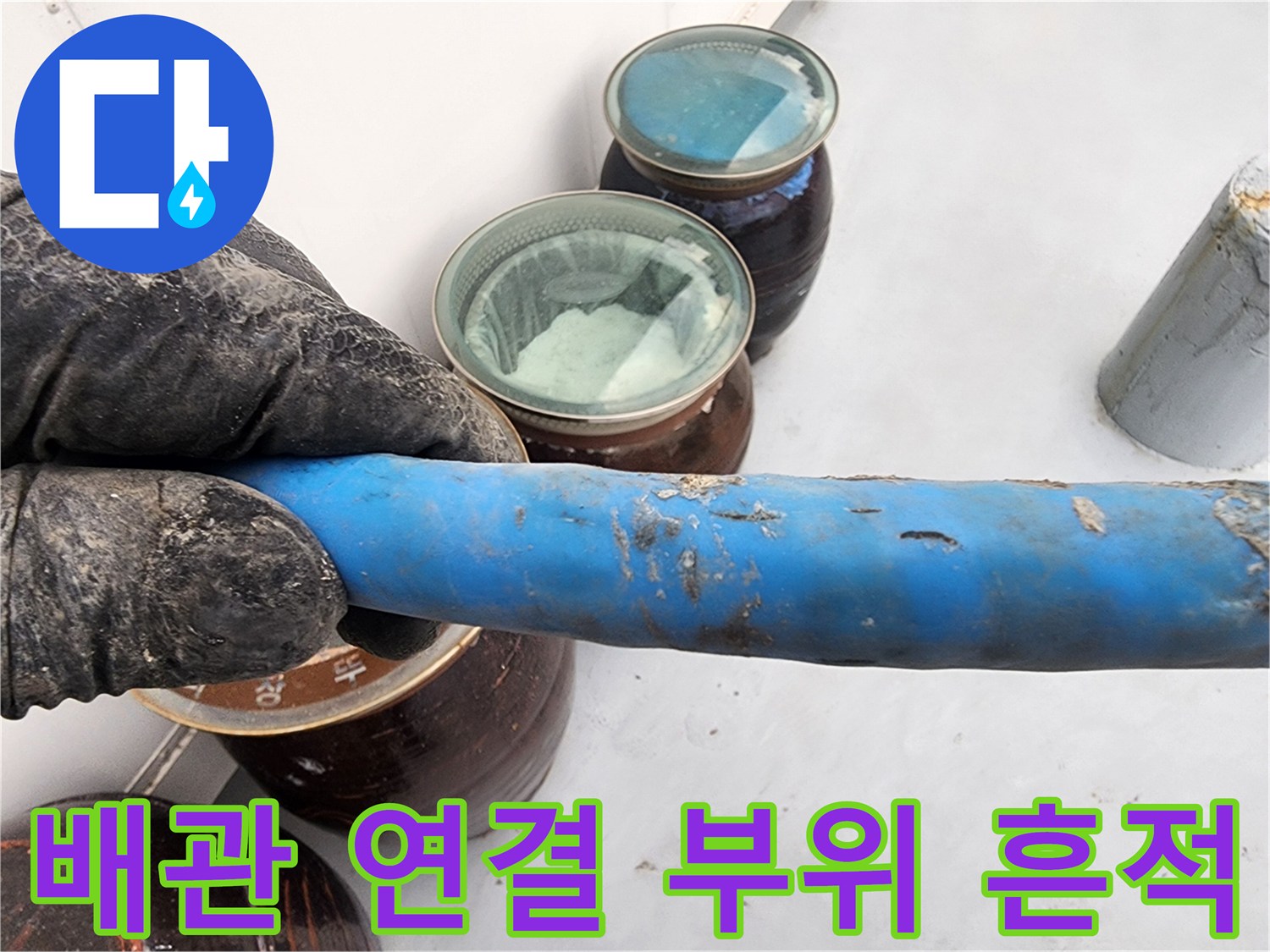누수가 의심되는 배관 연결부와 파란색 배관의 근접 사진입니다.