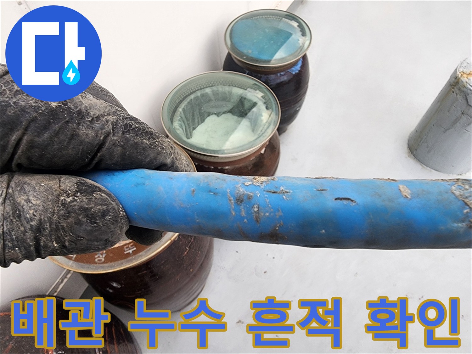 파란색 배관의 젖은 표면을 통해 누수 지점을 면밀히 탐색하는 엔지니어의 모습입니다.