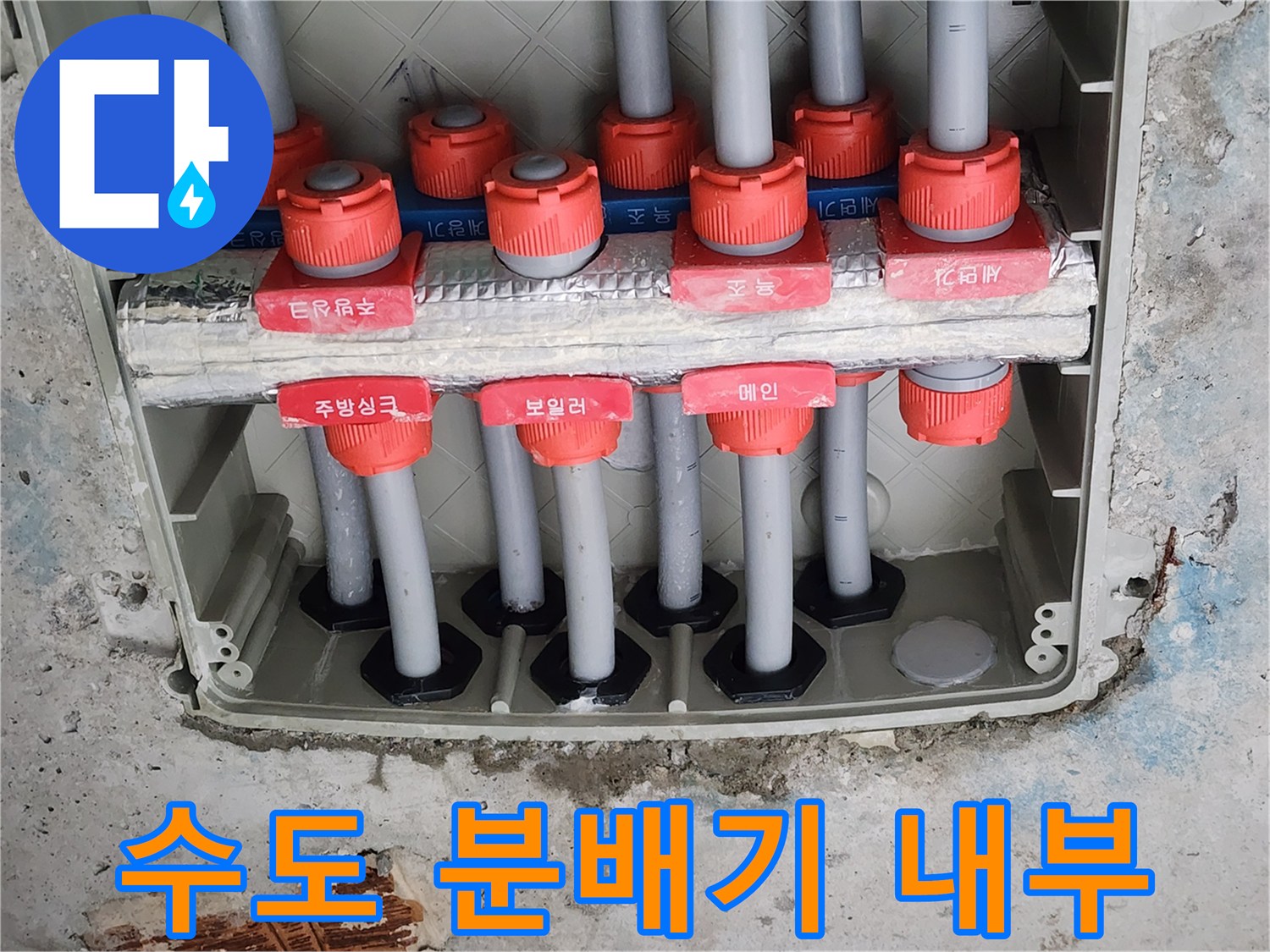 분배기 함 내부에 노출된 여러 개의 수도 배관과 밸브