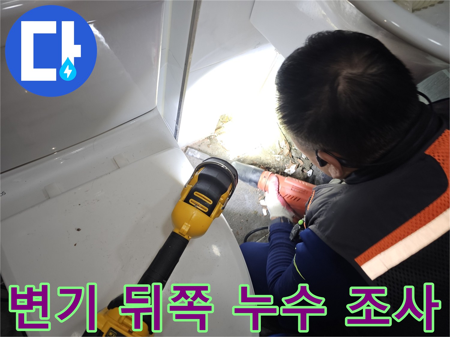 손전등 빛을 이용해 변기 뒷벽 배관 틈새를 면밀히 조사하는 모습입니다.
