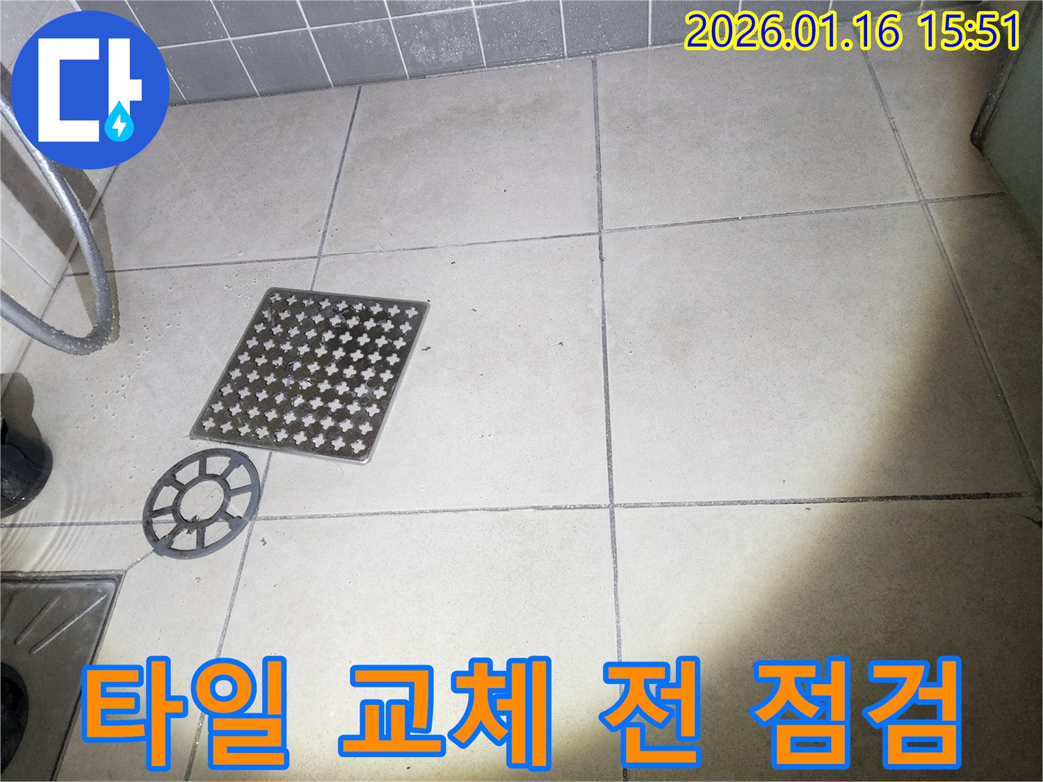 이 이미지는-욕실 배수구 커버를-제거하고-주변 타일 교체 전-상태를-점검하는-장면을 보여줍니다