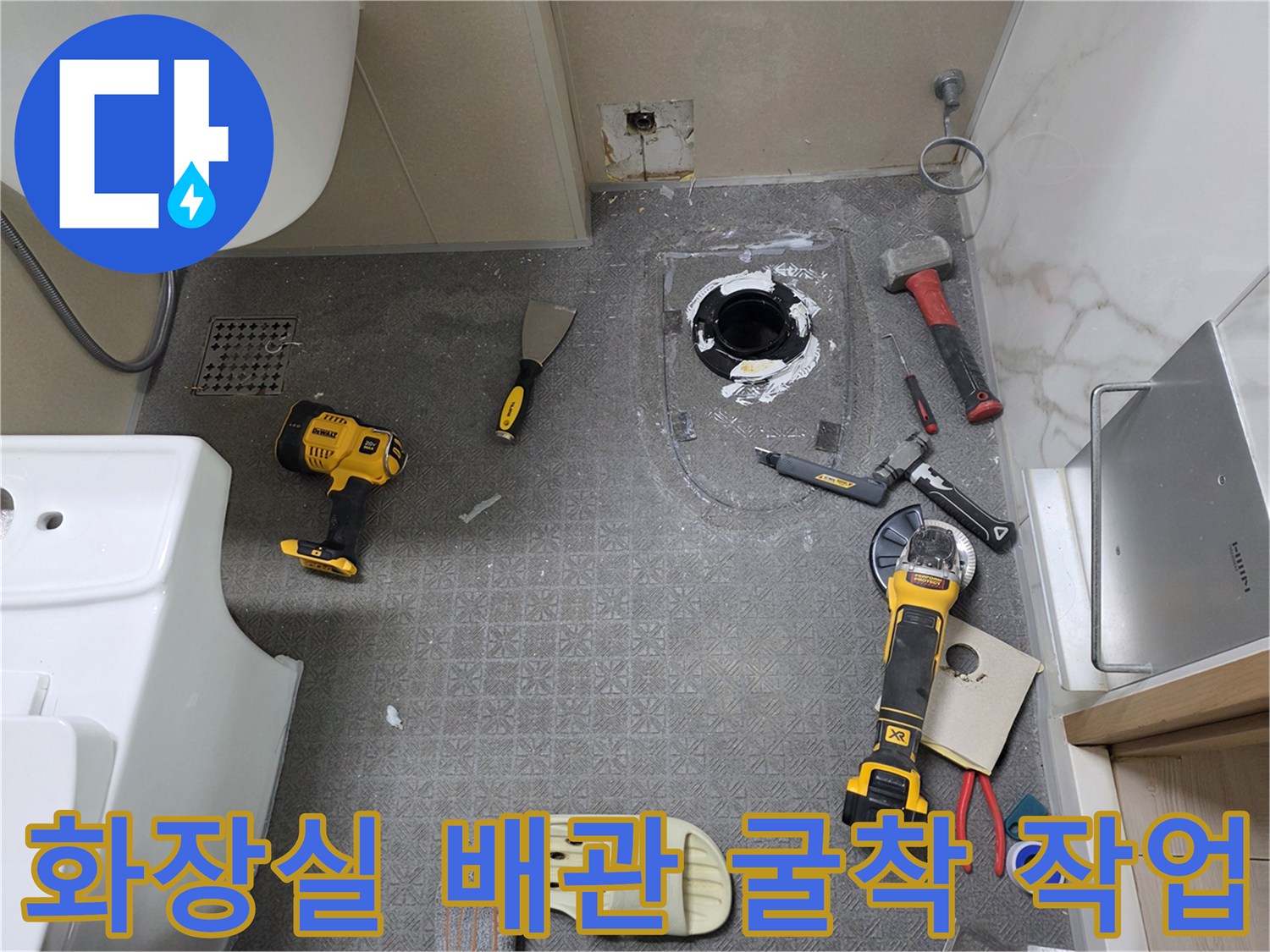 변기 배관 수리를 위해 바닥 타일과 판넬을 일부 절개한 현장 모습입니다.