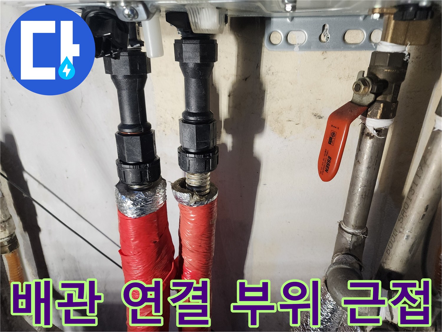 보온재로 감싸진 붉은색 배관과 금속 부품의 상세 사진