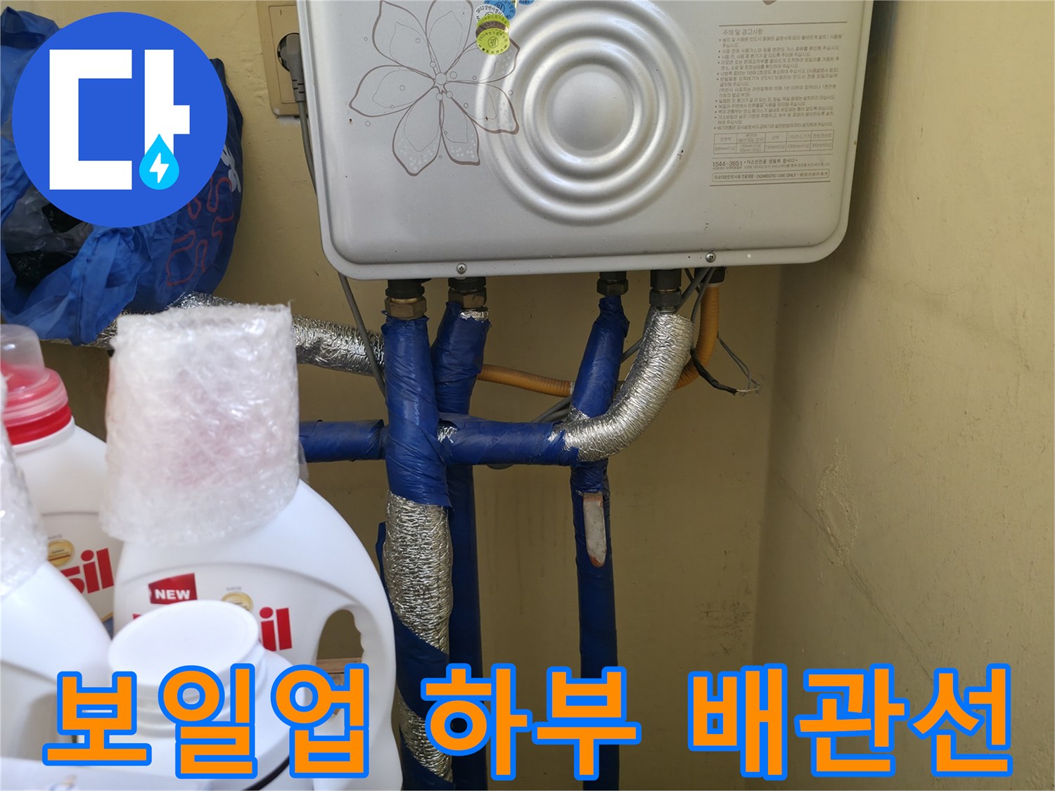 보일러 본체 아래로 연결된 여러 갈래의 급수 배관입니다.