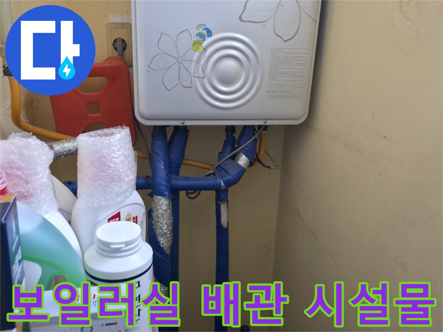 보일러 아래쪽으로 뻗어 나온 다양한 색상의 급배수 배관들