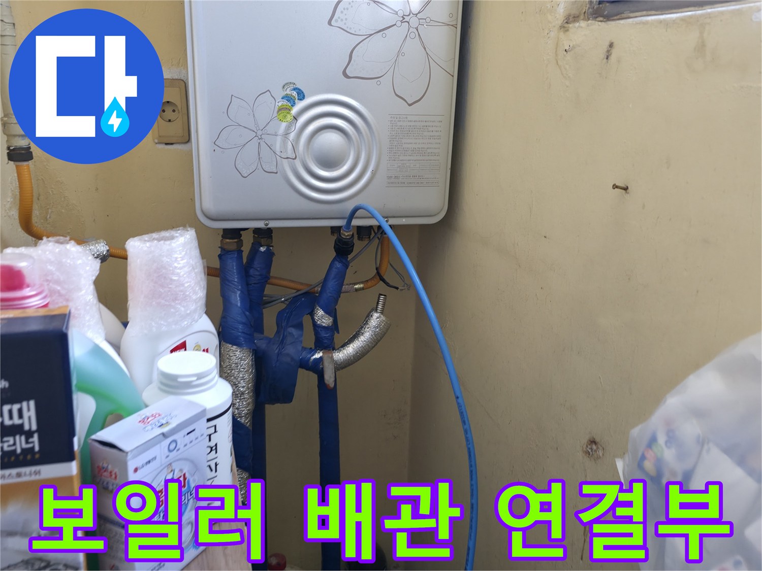 보일러 하단에 연결된 파란색 호스와 금속 부속들