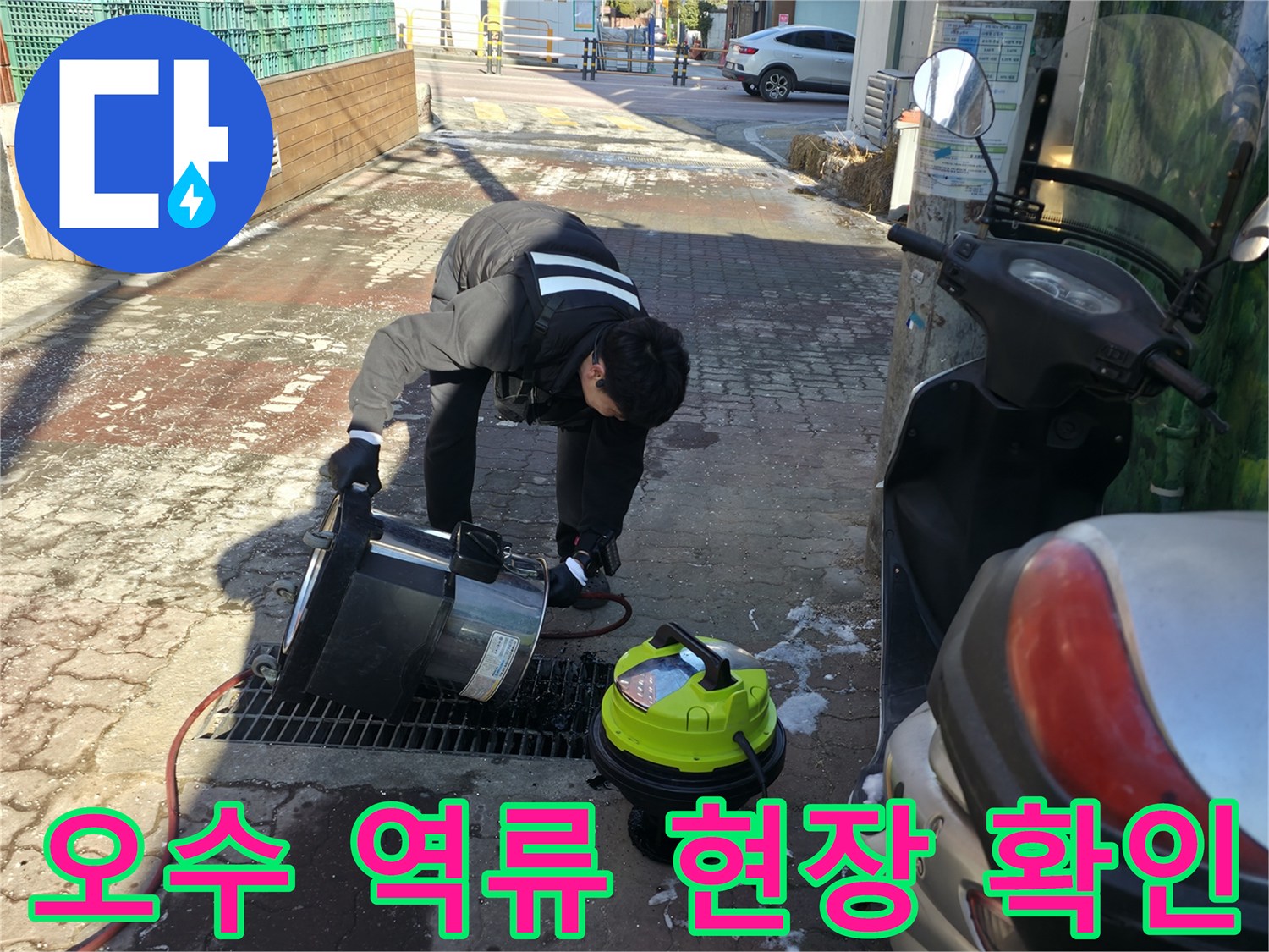 바닥에 고인 오수를 제거하기 위해 흡입기를 사용하는 장면