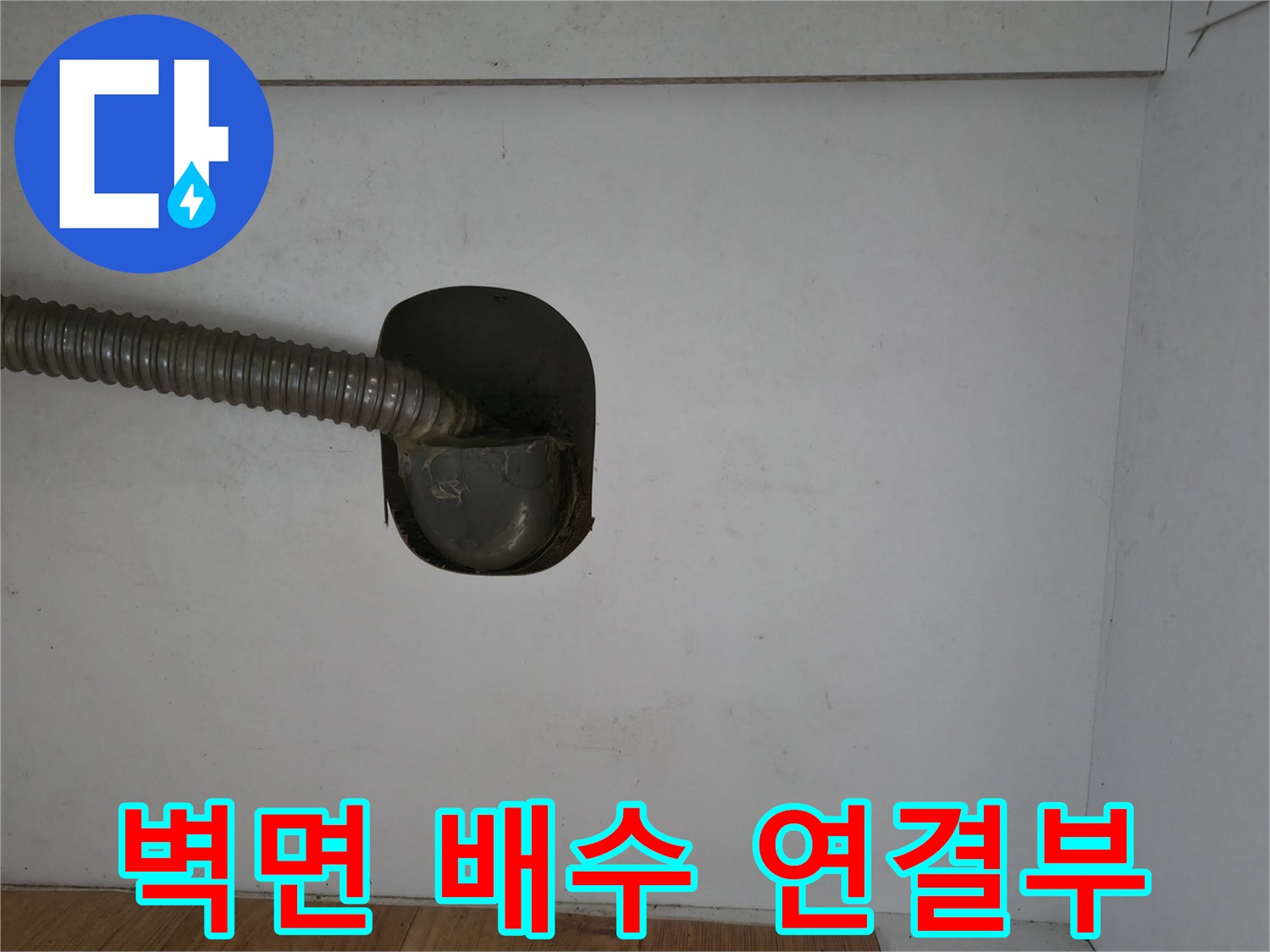 벽체 배수구에 연결된 은색 주름관의 상세 모습입니다.
