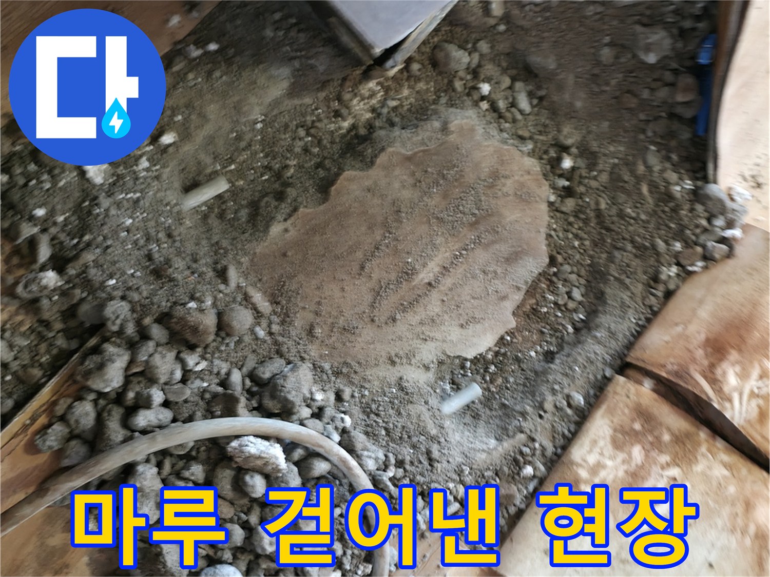 누수 지점을 확인하기 위해 거실 마루를 들어내고 바닥을 파낸 사진입니다.
