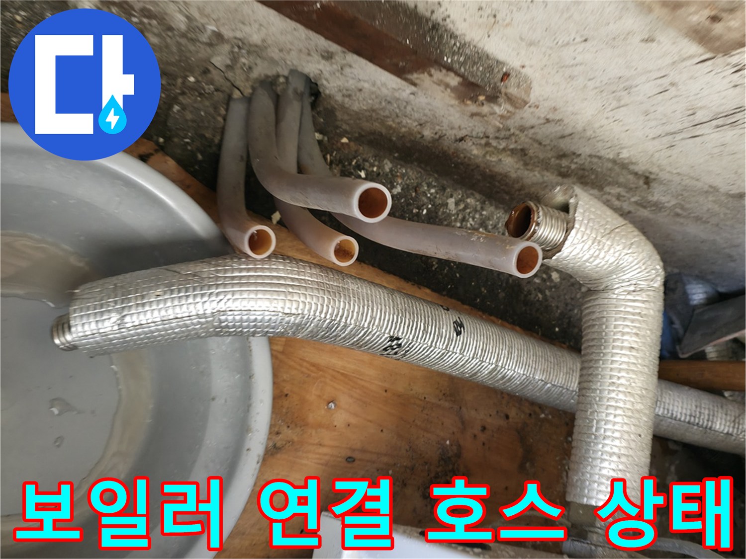 보일러-아래쪽의-분홍색-호스와-금속-보온재-배관