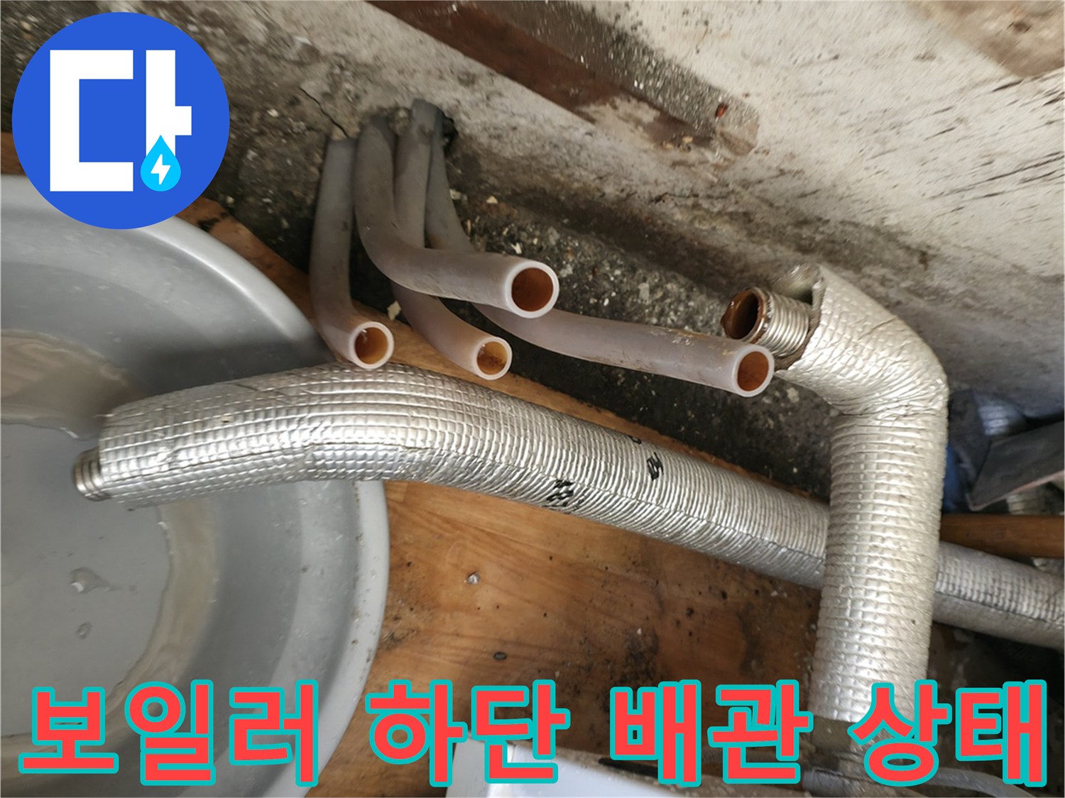 보일러 하단에 연결된 은색 보온재 배관과 분기되는 엑셀 배관의 모습입니다.
