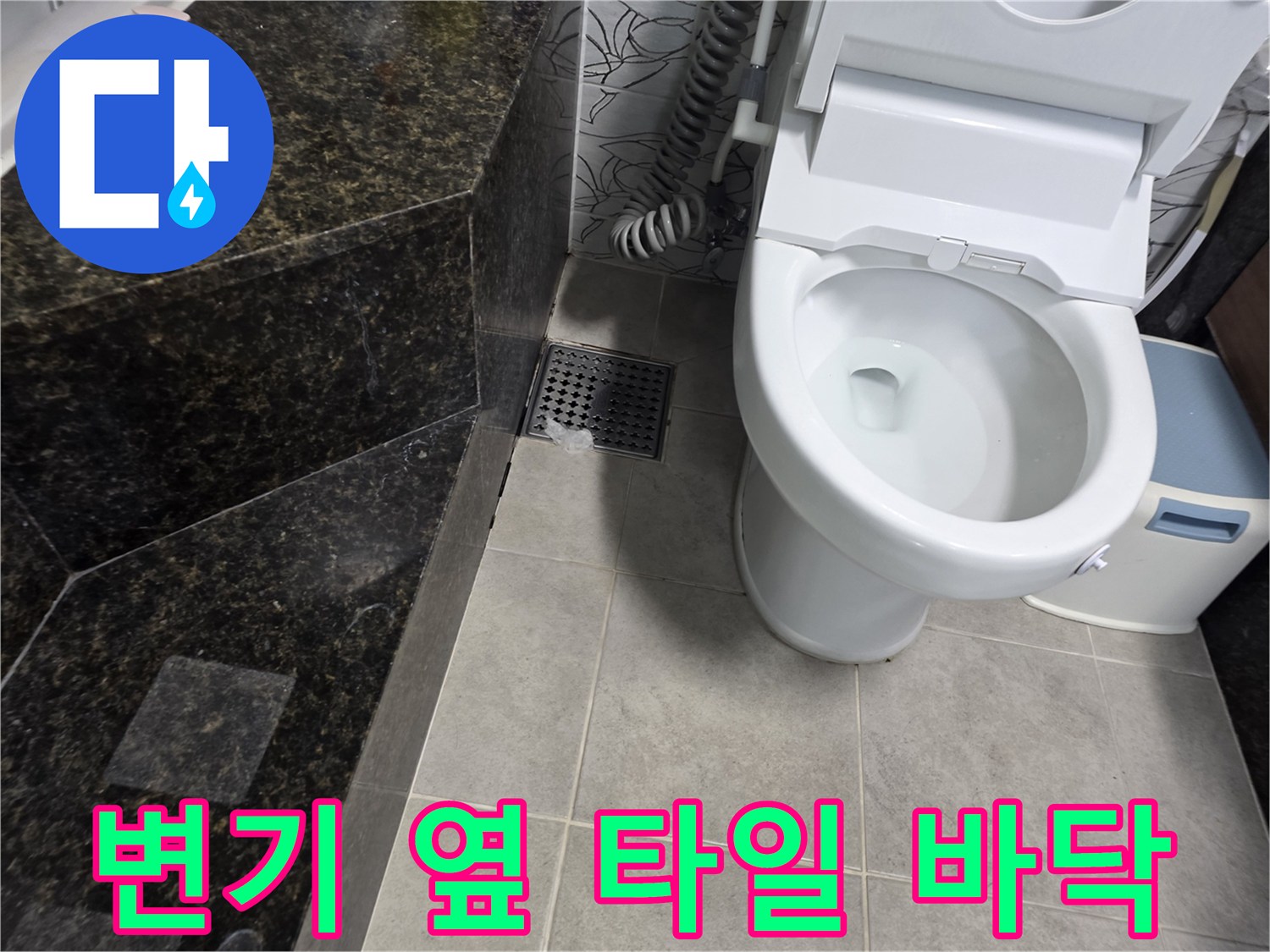 화장실 변기 옆 하수구 유가와 타일 마감 부위 사진입니다.