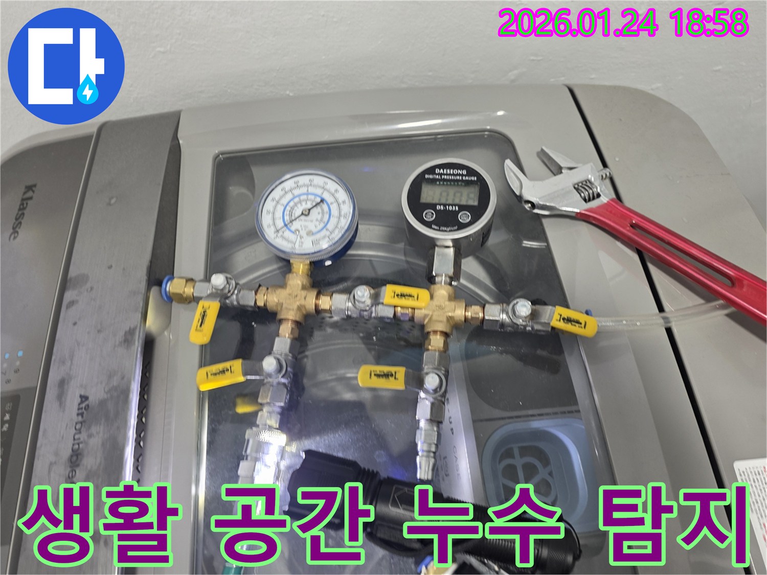 생활 공간 누수 탐지 - 세탁기 위에서 정밀 장비를 사용하여 배관의 압력을 측정하며 누수 원인을 찾습니다.