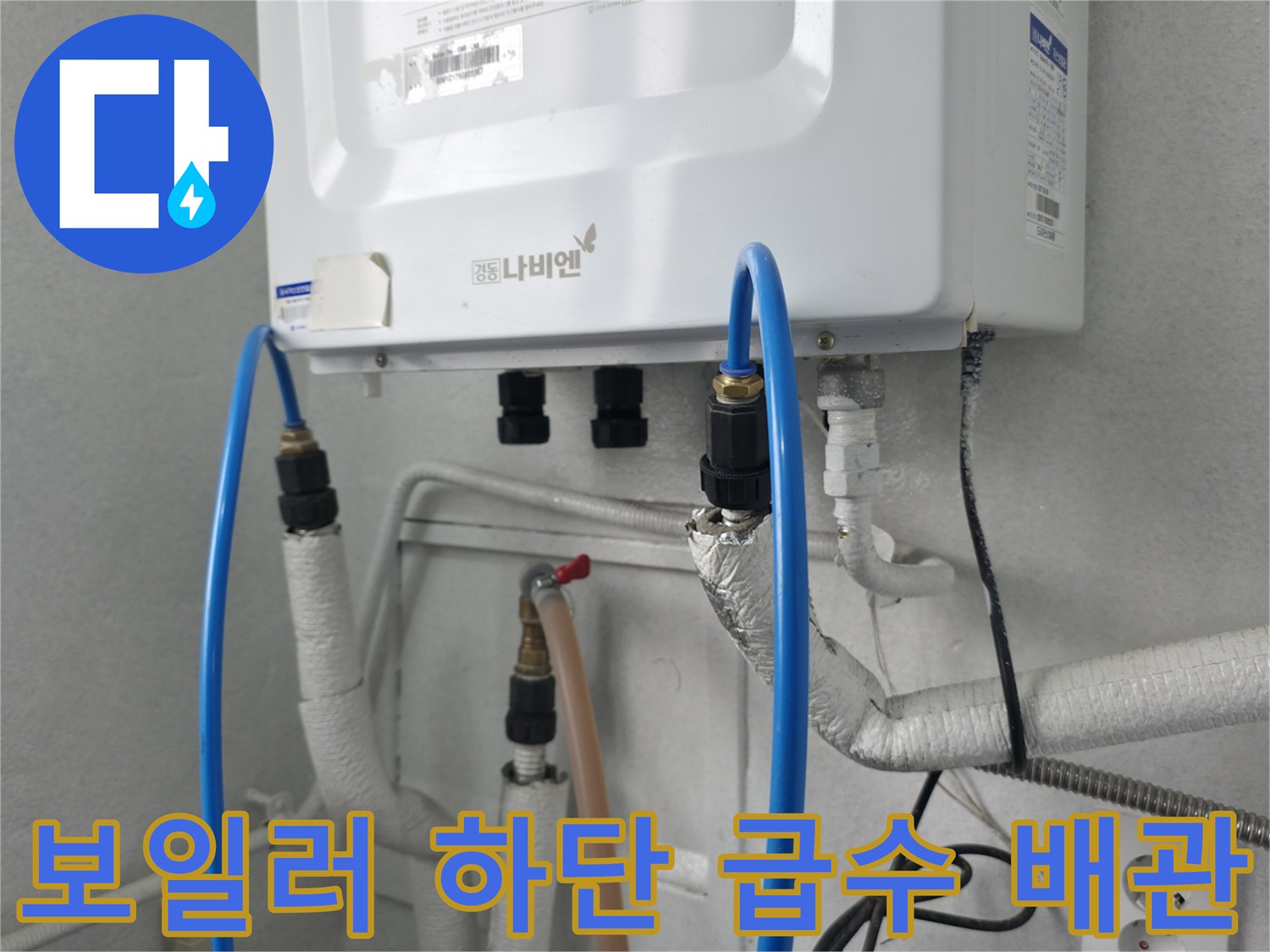 보일러 본체 아래쪽으로 연결된 파란색 및 흰색 배관들의 모습