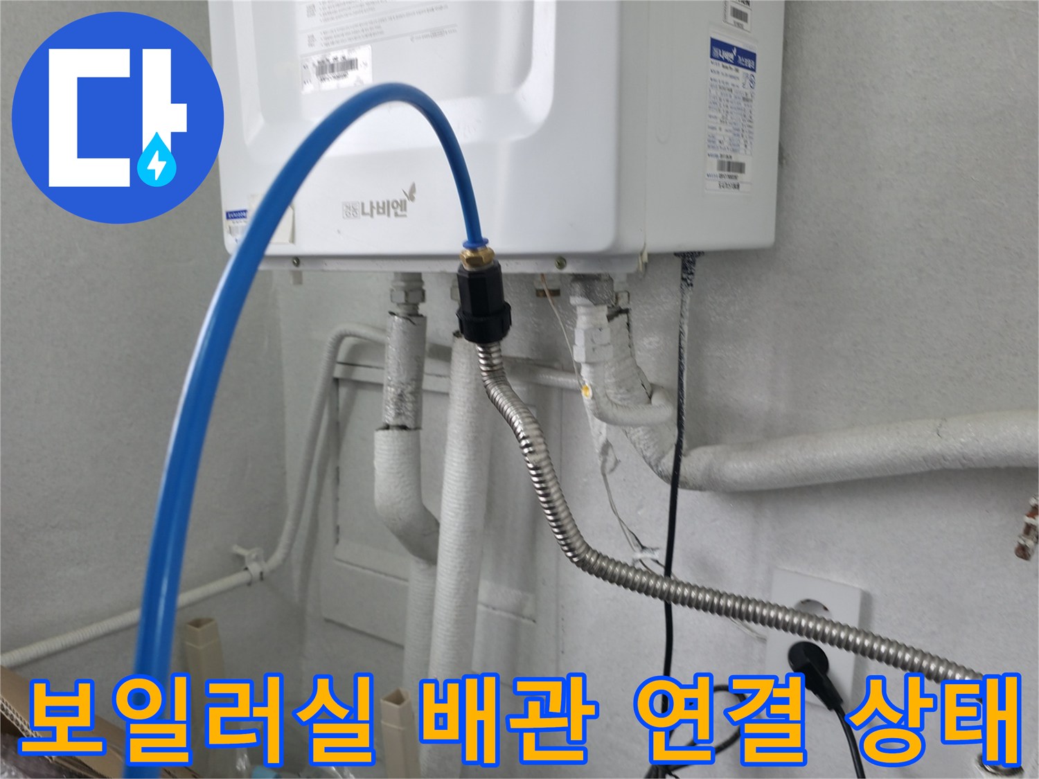 보일러 하단에 연결된 파란색 호스와 금속 자바라 배관 모습