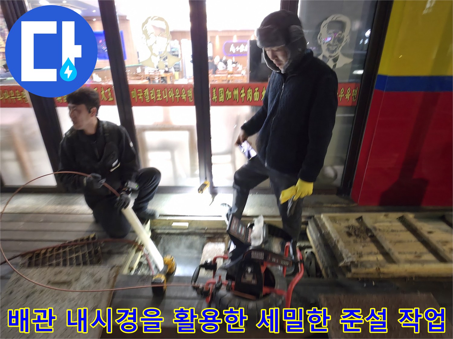 작업자가 전문 장비를 사용하여 배관 내부를 청소하는 긴박한 현장 모습