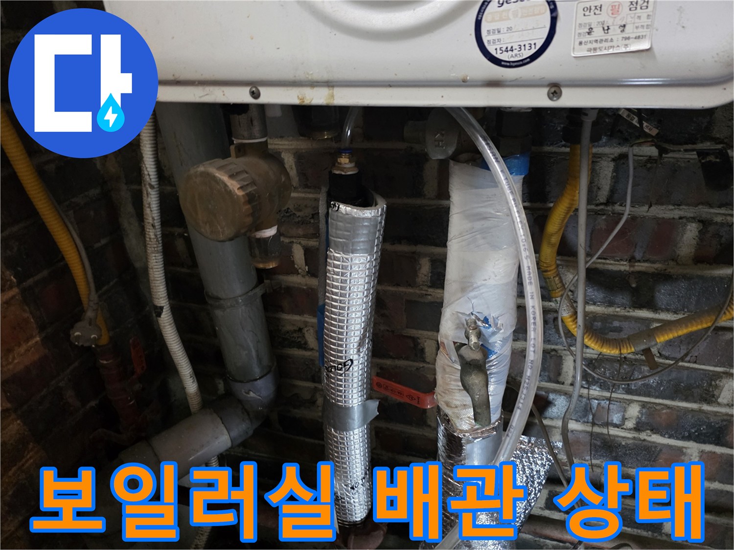 보일러 아래쪽의 복잡한 배관과 보온재 마감 상태를 보여주는 사진