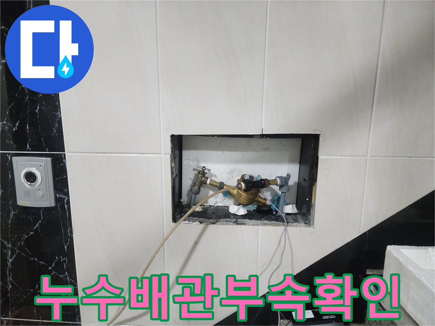 벽면 굴착 부위 내부에 노출된 금색 수도 배관과 연결 부품