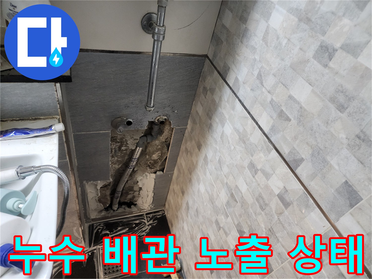 파손된 벽면 내부의 수도 배관과 젖은 시멘트 부위