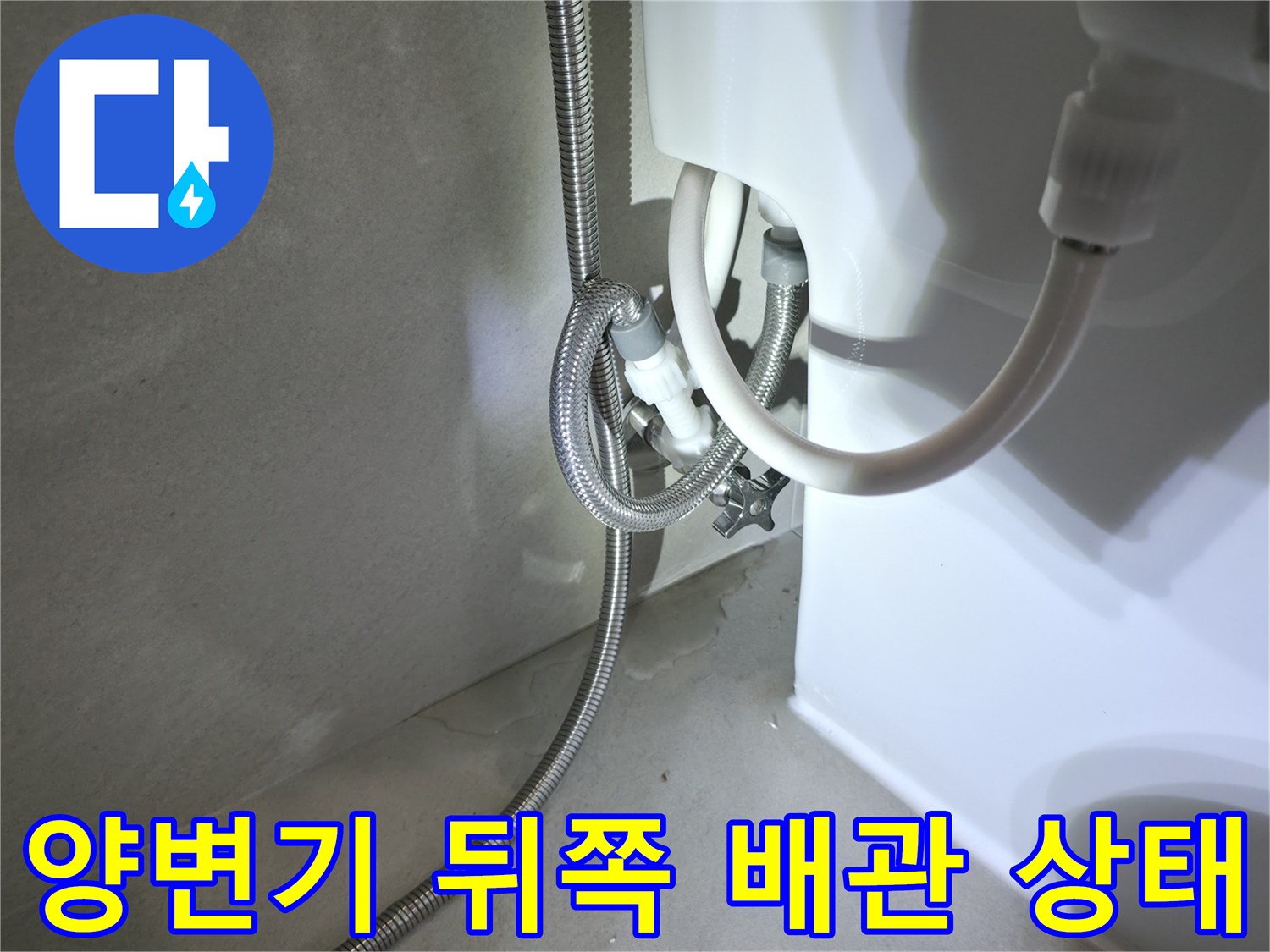 벽면 밸브와 변기 호스가 연결된 지점의 클로즈업 사진