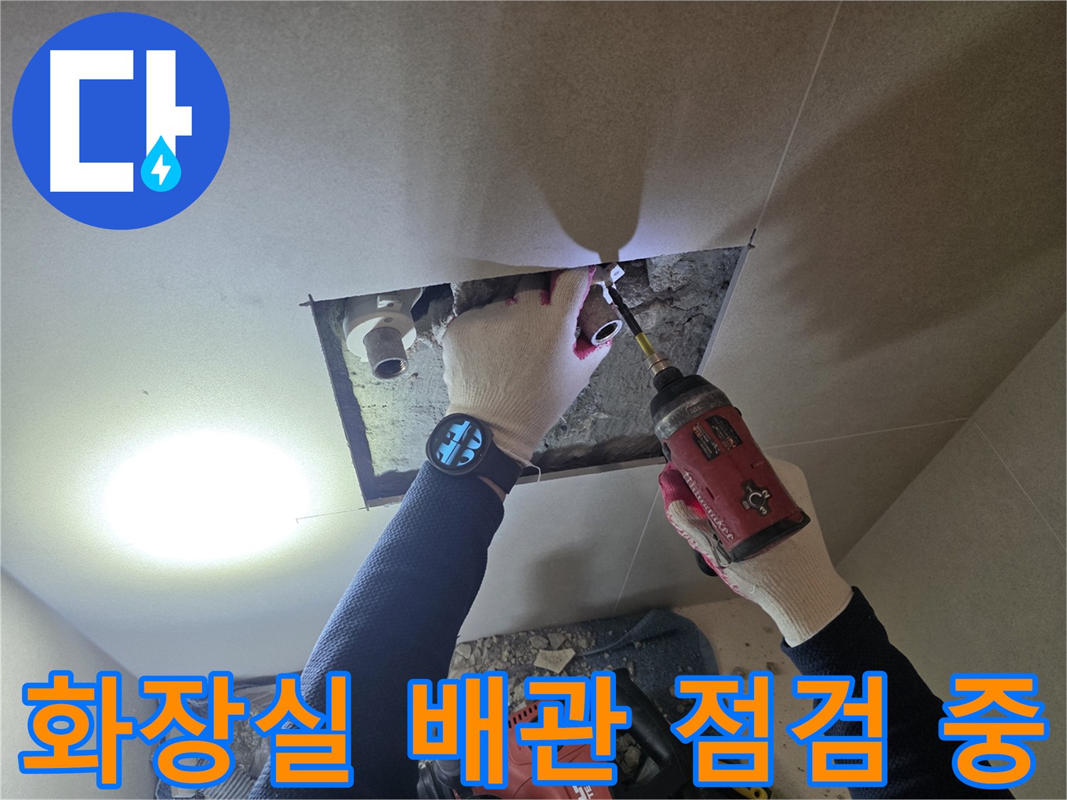 파주 현장에서 작업자가 전동 공구를 사용하여 화장실 벽면 내부의 매립 배관 부위를 확인하고 있습니다.