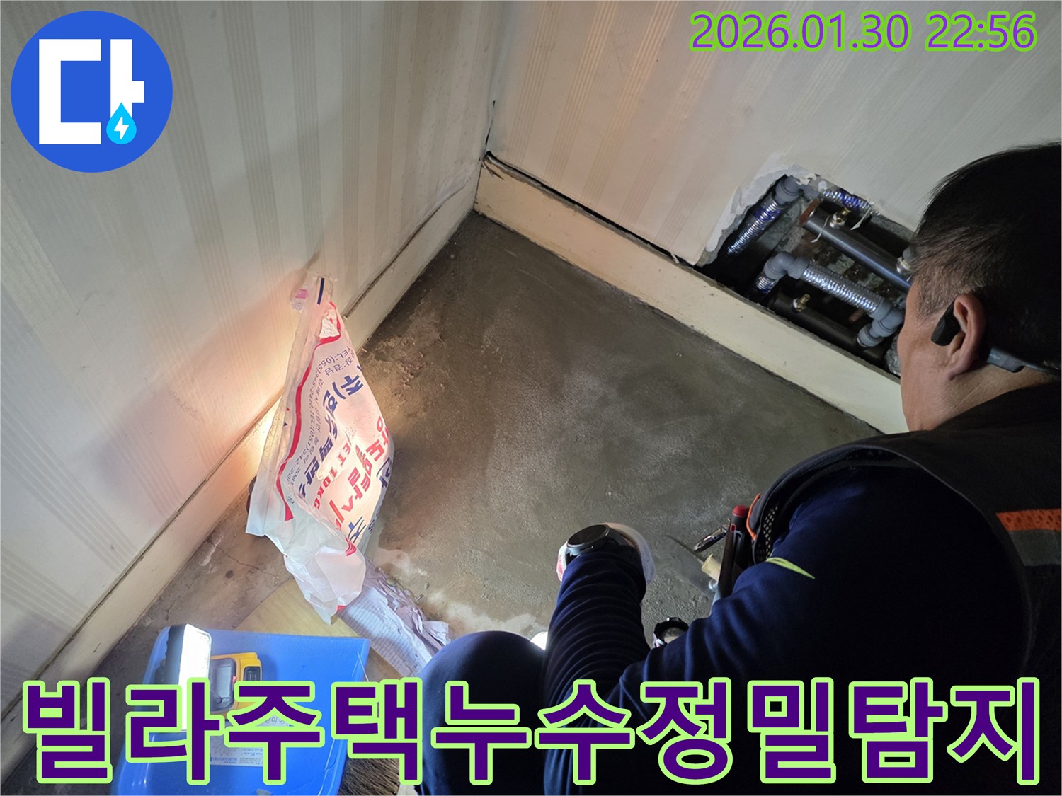 누수-전문가가-빌라-또는-주택의-좁은-공간에서-배관을-조명으로-밝혀-누수-여부를-확인하는-장면입니다
