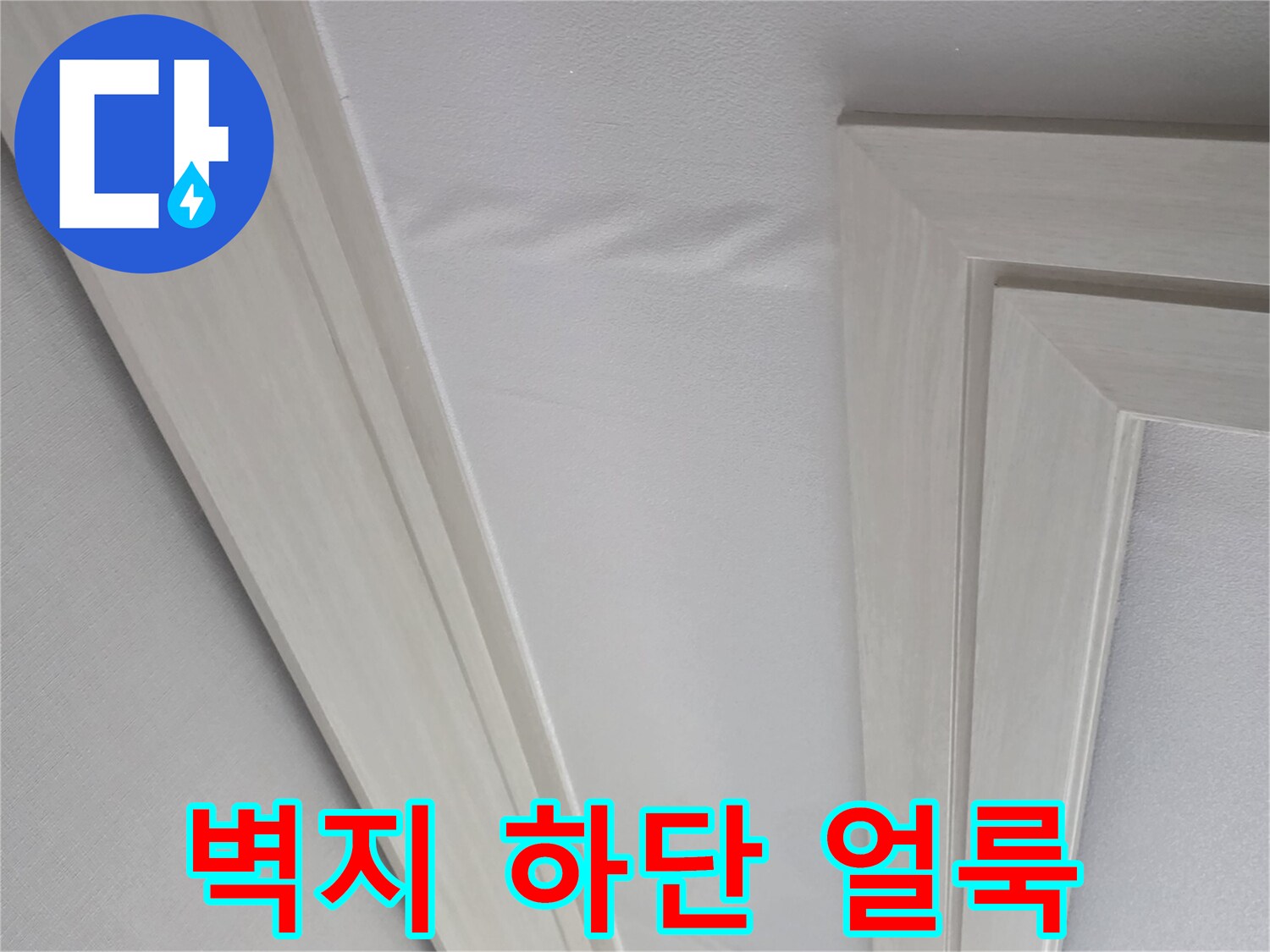 몰딩 근처 벽지의 젖은 자국과 변색된 부위