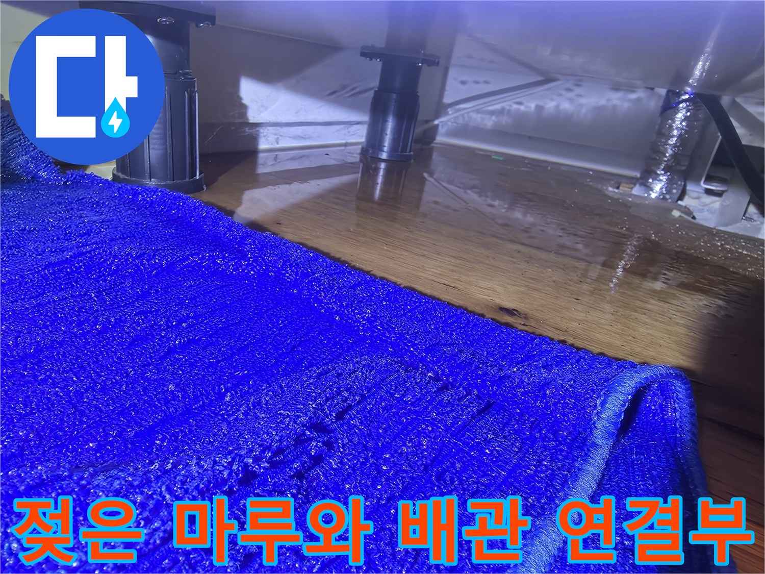 싱크대 하부 구조물-주변 마루가 젖어 있는 모습
