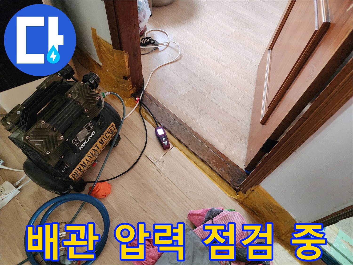 바닥에 놓인 가스 탐지기와 연결된 배관 검사용 장비 세트