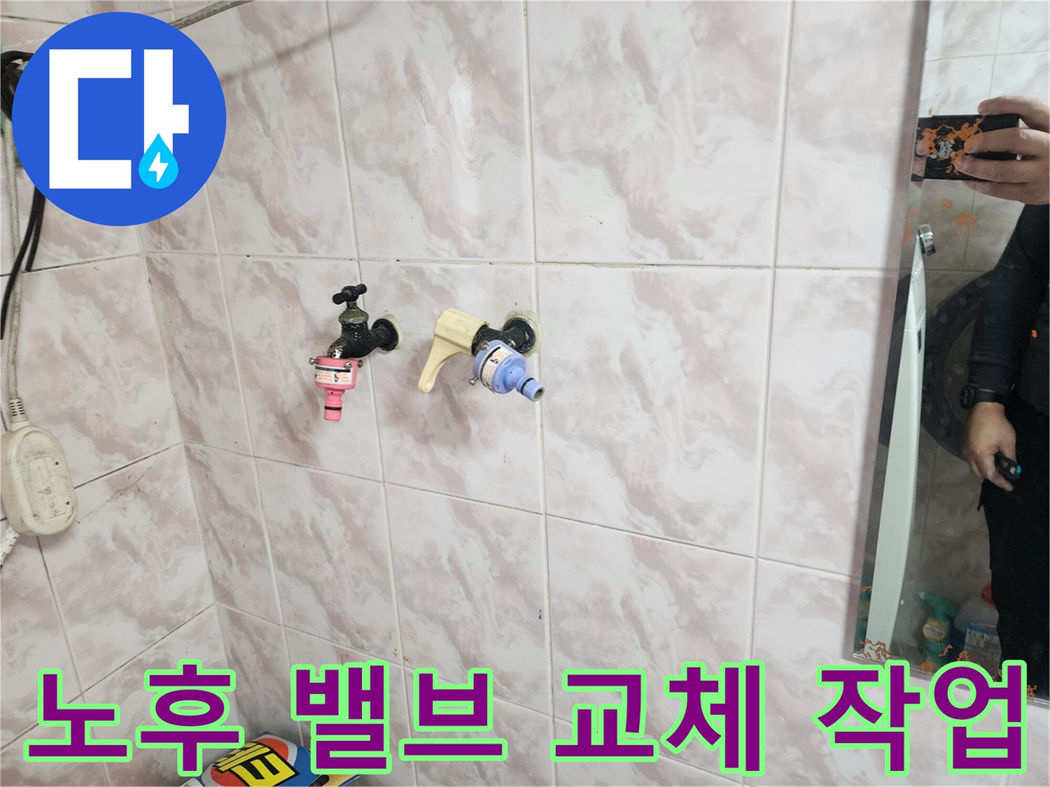 욕실 벽면 타일 사이로 드러난 새로 설치된 수도 연결 부속입니다.