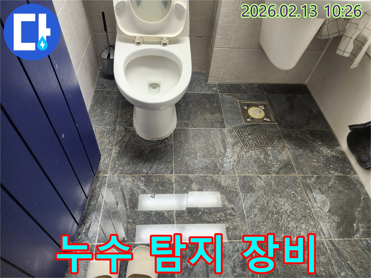 화장실 바닥의 젖은 타일을 배경으로-누수 탐지 장비가 놓여있거나 사용될 준비가 된 모습
