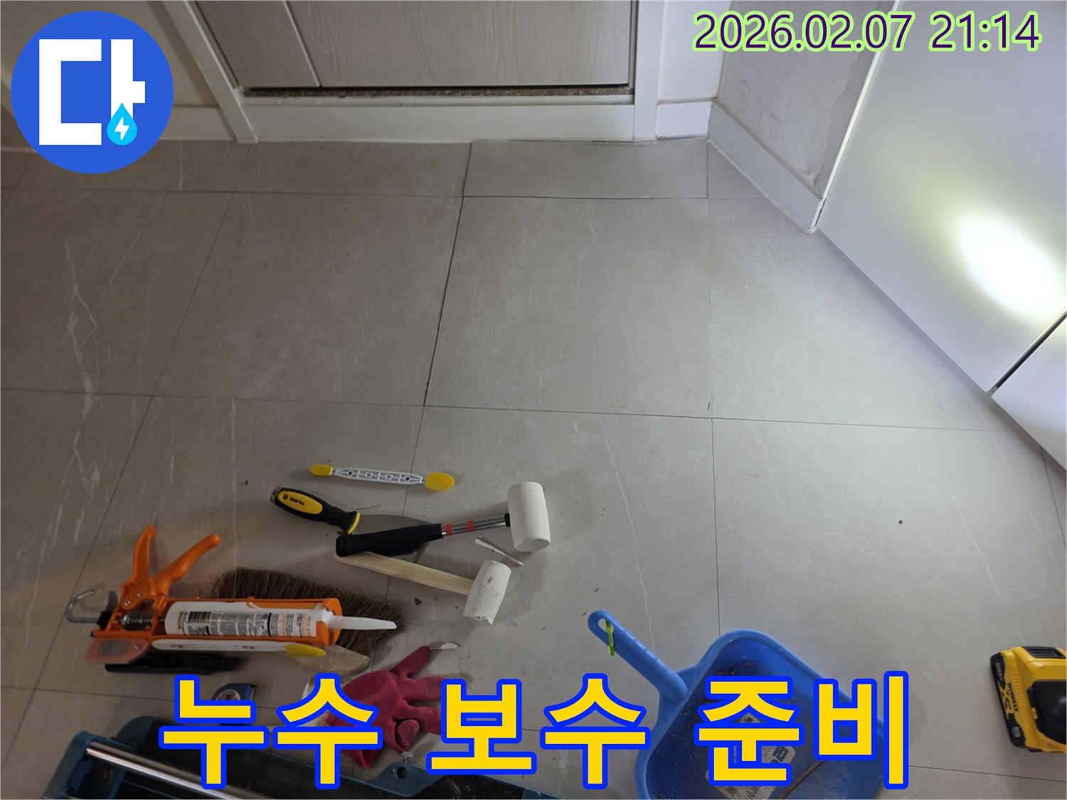 누수 보수 작업을 위해 타일 바닥에 놓인 다양한 공구들입니다-이는 정밀한 누수 탐지와 완벽한 보수를 위한 필수적인 준비입니다