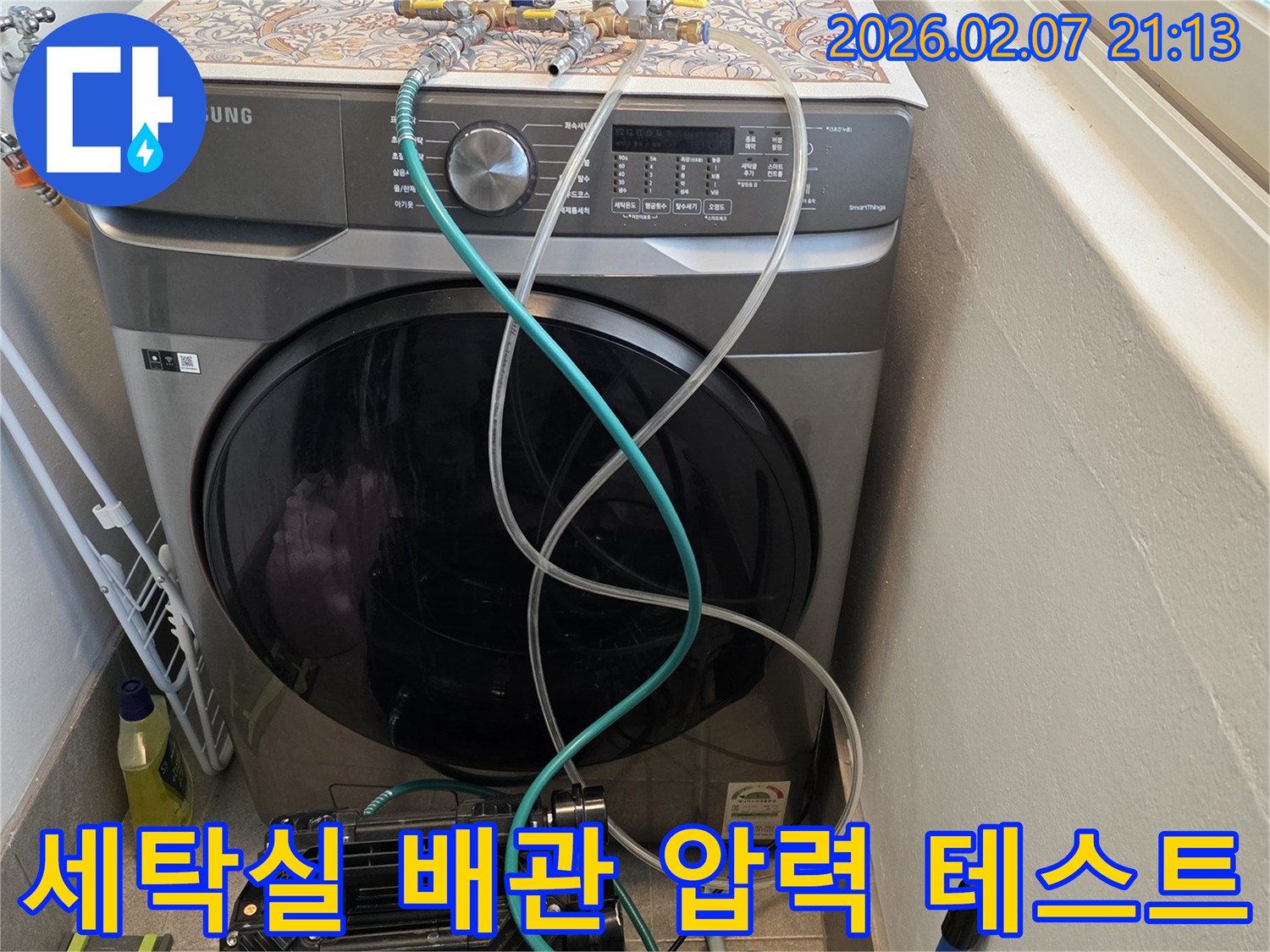 세탁기 옆-배관에-연결된-누수탐지-장비로-정밀-압력-테스트를-진행-중입니다
