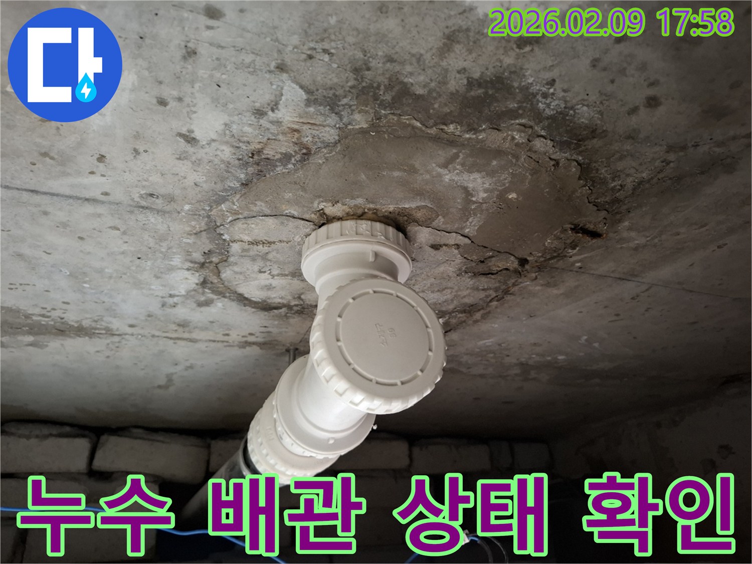 천장 콘크리트에 설치된 배관-누수로 인한 손상 부위를 면밀히 관찰하는 사진