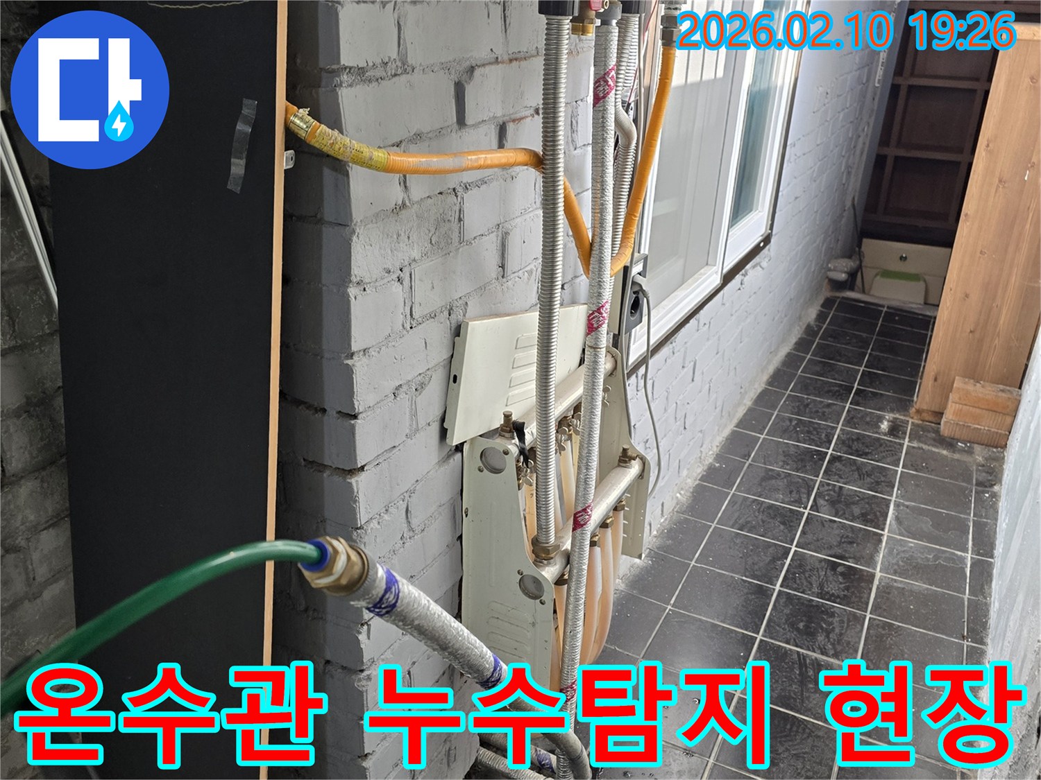 빌라-외벽에-설치된-온수-배관에서-누수-탐지-작업을-진행하는-모습