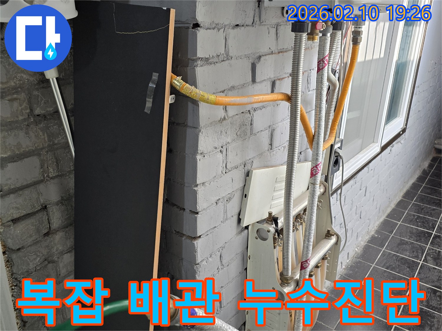 이 이미지는 외벽에 복잡하게 얽힌 배관들 사이에서-누수 지점을 찾아내기 위한 정밀 탐지 과정을 담고 있습니다