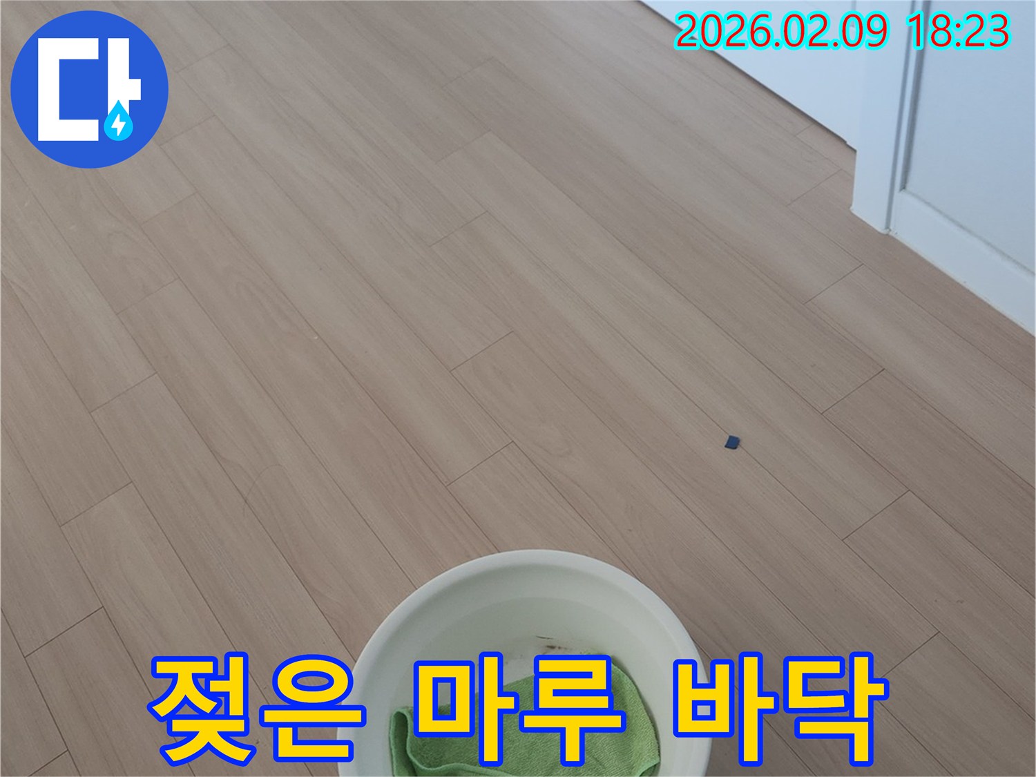 누수-발생으로-인해-마루-바닥에-물이-고여-있어-물받이와-걸레로-응급-조치한-모습