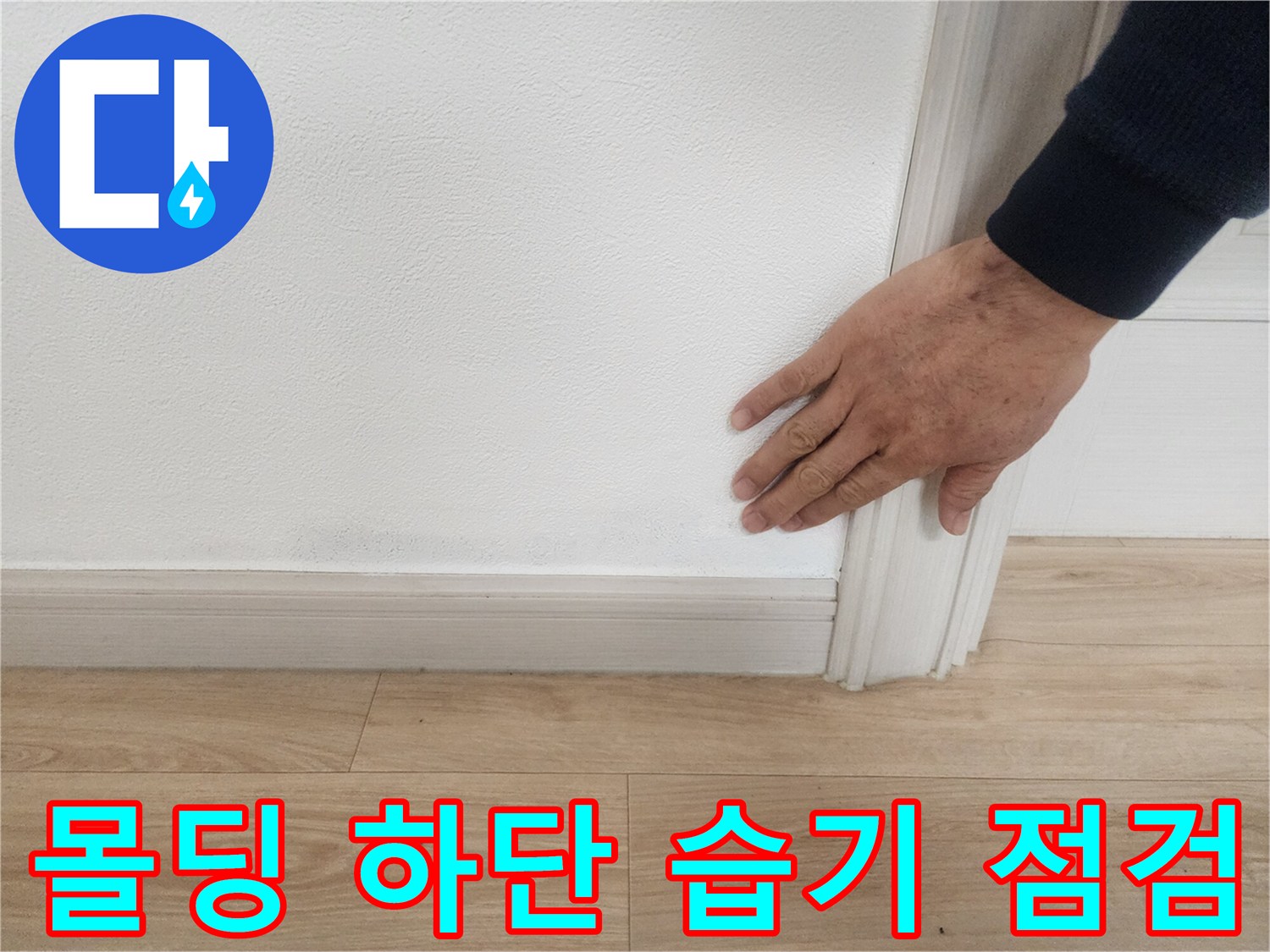 걸레받이와 벽면 접촉 부위의 변색된 지점을 손으로 짚고 있는 장면