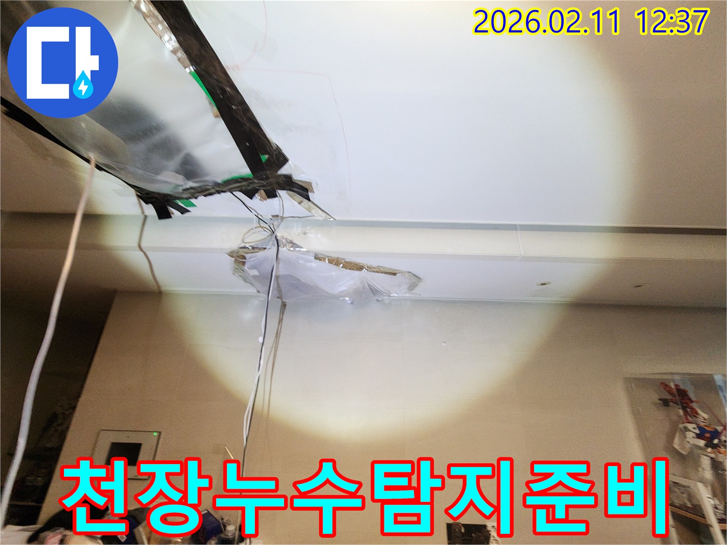 천장 마감재가 뜯겨진-누수 현장에서-탐지 장비 준비 중인-모습을 담은 사진