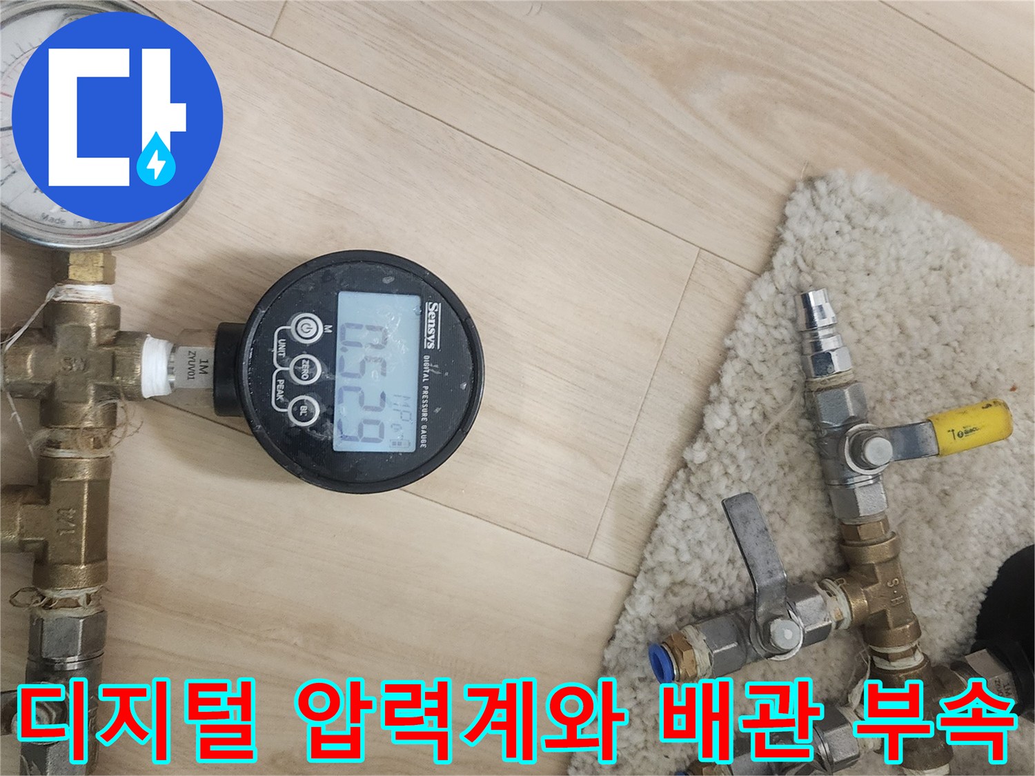 천장 분배기 배관에 연결된-디지털 압력계와 수전 부속품들