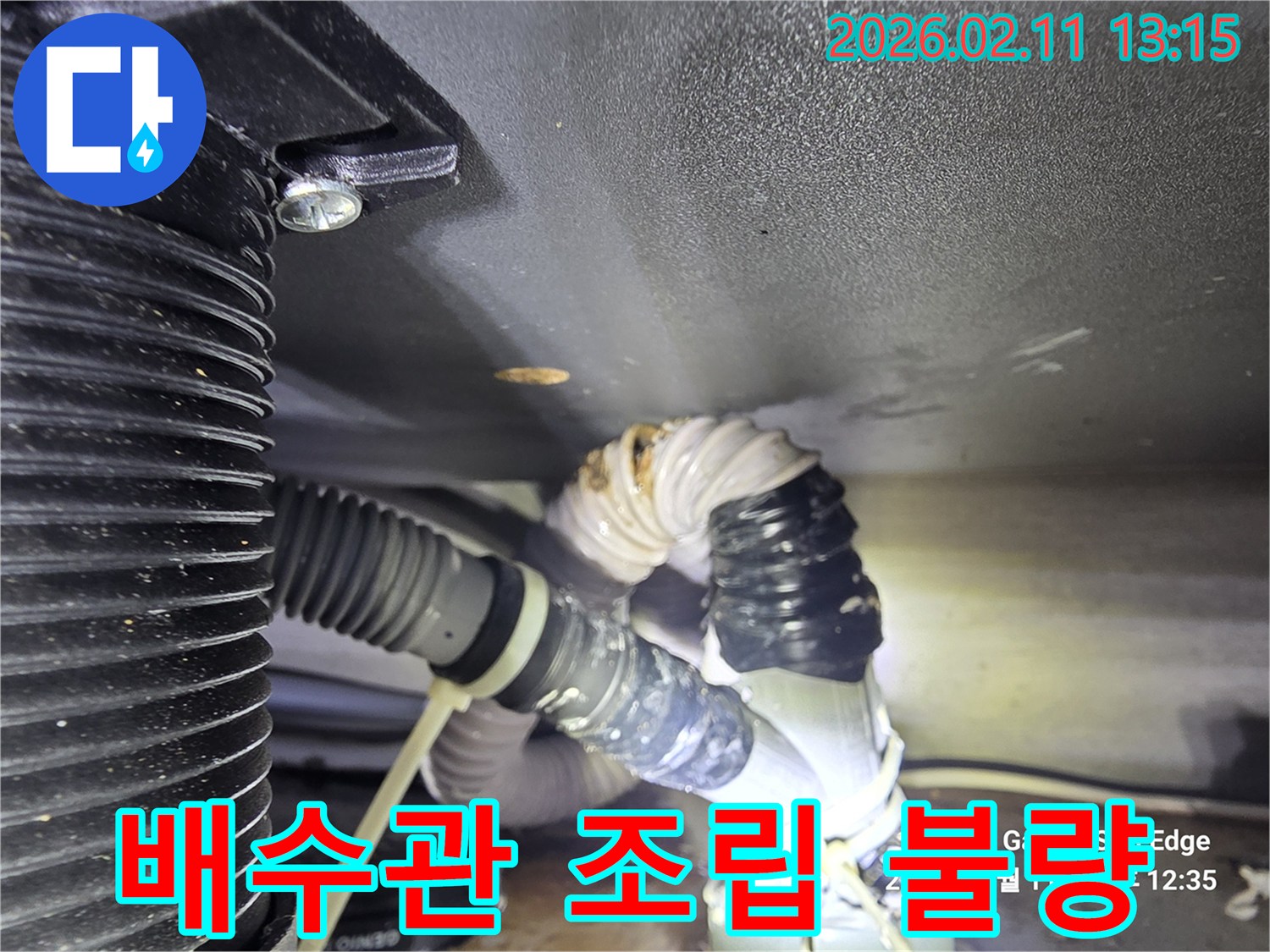 싱크대 배수관의 조립 불량으로 인해 물이 새는 현장을 담은 사진입니다-연결 부위의 틈새와 물기가 보입니다