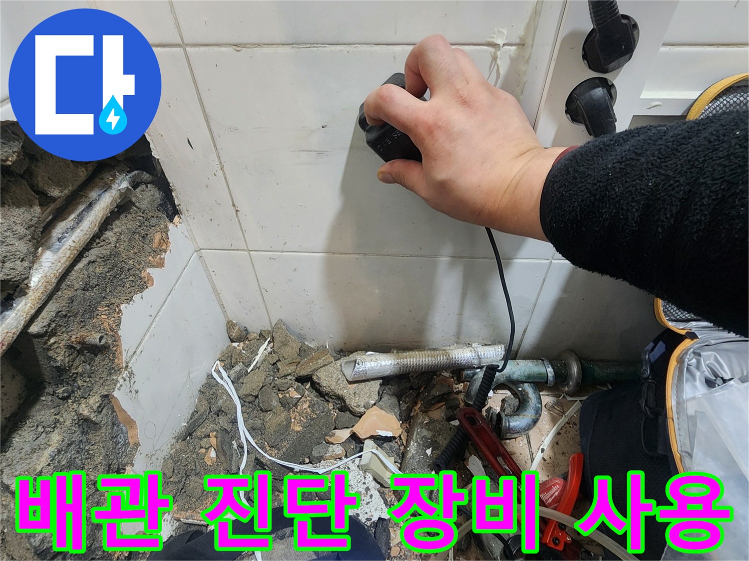 누수 지점을 찾기 위해 가스 탐지기를 벽면에 대고 확인하는 모습