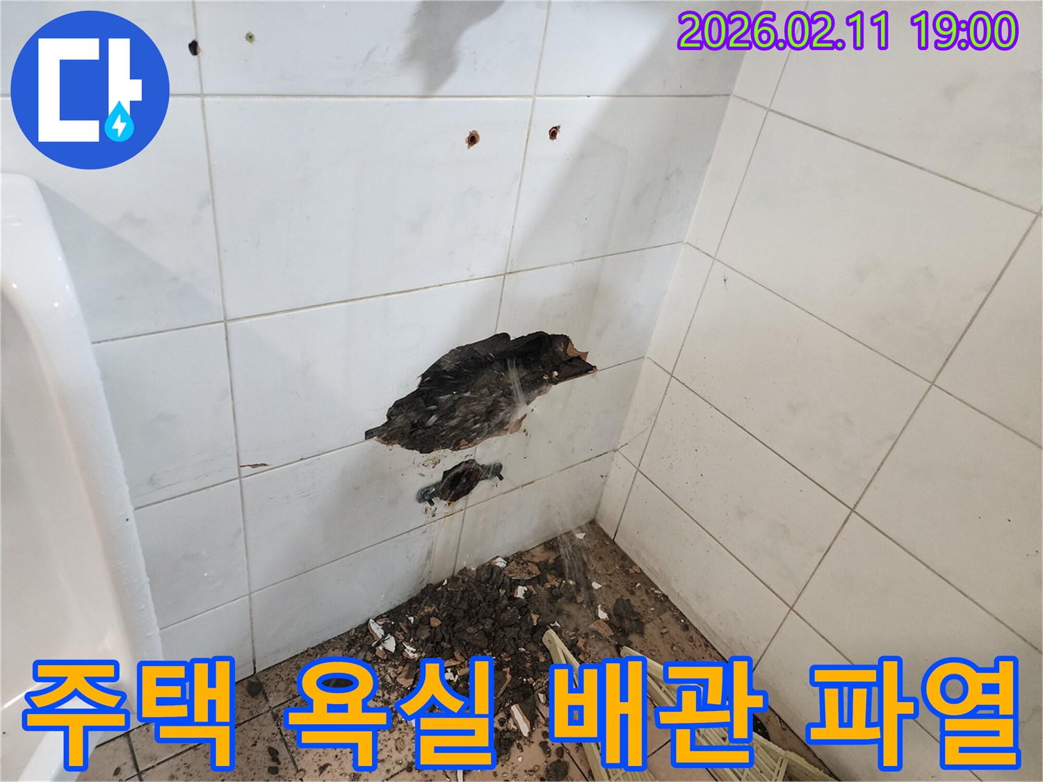 주택 욕실 벽 타일이 깨지고-배관 파열로 물이 새는-긴급 누수 공사 현장을-전문가가 점검하는 모습