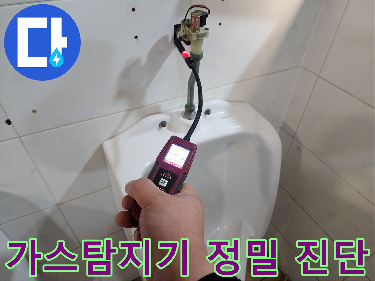 화장실 변기 근처에서 가스 탐지기를 이용해 배관 누수를 찾는 모습