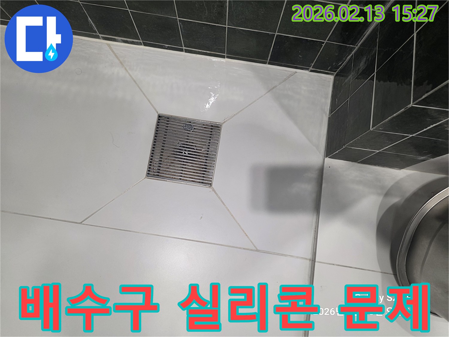 화장실 배수구 주변에 물이 고여있고-실리콘 마감-이 의심되는-누수 현장-을 촬영한 이미지입니다.